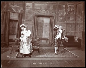 Kohtaus harrastajatuotannosta "She Stoops to Conquer" (hopeagelatiinipaino).
